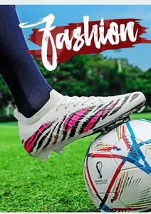 Chaussure de foot en maille avec crampons AG/TF sur un terrain en herbe.
