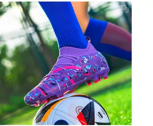 Detailed view of purple flying knit soccer cleats with splatter pattern on a field
