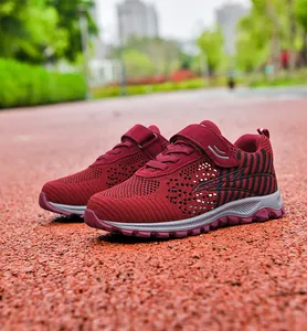 Detailed view of wine red fly-knitted walking shoes with breathable mesh on track