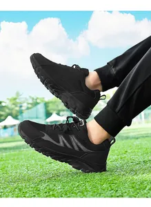 Close-up of black mesh athletic walking shoes worn on green grass in a bright outdoor setting