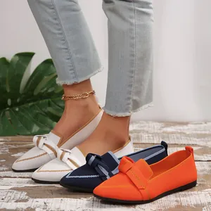 Gros plan sur des mocassins confortables en maille pour femme, blanc et orange.