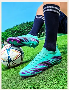 Vue détaillée de chaussures de football en tricot turquoise sur un terrain de gazon