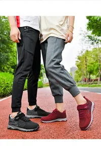 Detail of breathable mesh unisex fly-knit walking shoes in black and burgundy colors