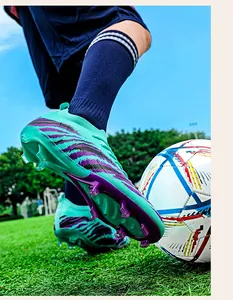 Gros plan d'une chaussure de foot Flyknit vert menthe avec crampons AG sur herbe