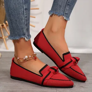 Gros plan détaillé de ballerines rouges en mesh à bout pointu avec nœud élégant et bordure noire