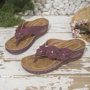 Primer plano de los detalles florales en estas sandalias de cuña para playa en morado