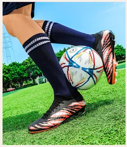 Chaussures de foot professionnelles fly-knit avec motif tigre et crampons AG sur terrain.