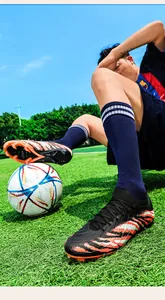 Gros plan de chaussures de football en maille avec rayures de tigre sur gazon