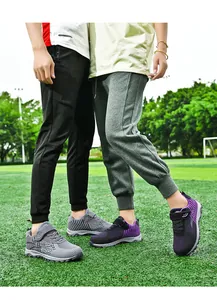 Outdoor detail of breathable fly-woven walking shoes for men and women on a grass field.