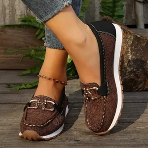 Vista detallada de mocasines vintage marrones para mujer en una plataforma de madera
