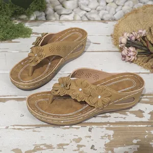 Vista detallada de chanclas con cuña para mujer con decoración de tres flores y suela