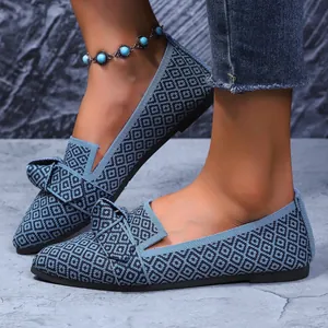 Gros plan sur des ballerines pointues en maille bleue avec motif géométrique et nœud