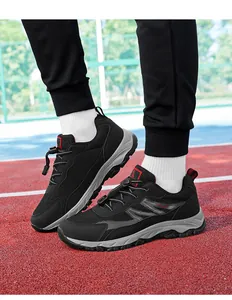 Close-up view of black breathable mesh walking shoes worn on a red and blue outdoor athletic track