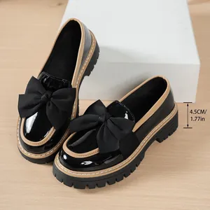 Detail of vintage black loafers with bow and 4.5cm platform heel height measurement.