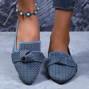 Gros plan sur des mocassins élégants en maille bleue à bout pointu avec un nœud décoratif chic