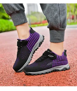 Detailed view of breathable purple and black fly-woven sneakers on a running track