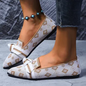 Détail de chaussures plates blanches à bout pointu en maille avec un joli nœud papillon