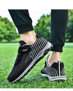Detailed view of breathable fly-knit walking shoes with non-slip soles on green grass