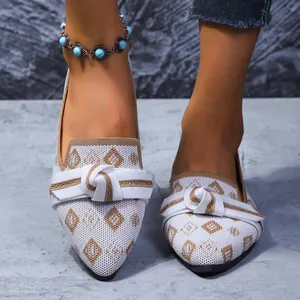 Vue détaillée de ballerines en tricot blanc à motif losange marron et nœud élégant.