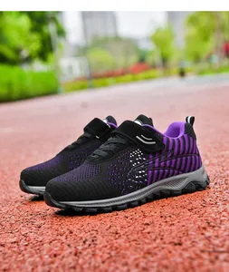 Breathable purple and black knit walking shoes displayed on an outdoor running track