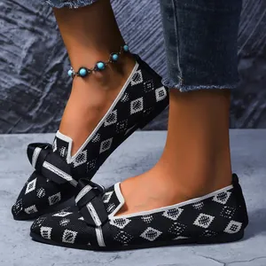 Gros plan de ballerines en tricot avec nœud et motif géométrique élégant.