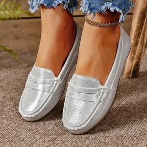 Detail view of silver glitter loafers featuring round toe and metallic finish texture