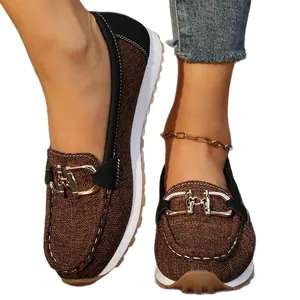 Mocasines vintage marrones cómodos para mujer con hebilla metálica y suela blanca sport.