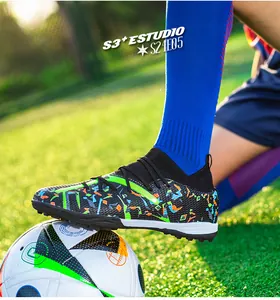 Detailed side view of fly-knit turf soccer shoes with colorful graffiti patterns on grass field