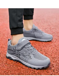 Close-up detail of gray breathable mesh fly-knit sports shoes on a running track
