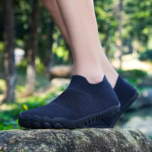 Gedetailleerd zijaanzicht van zwarte outdoor barefoot schoenen op een rotsblok