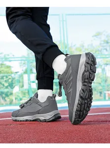 Close-up detail of grey breathable outdoor walking and running shoes on a red sports track