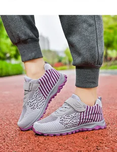 Close-up of breathable grey and purple mesh walking shoes on an outdoor track