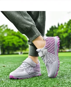 Close-up of lightweight purple and grey flyknit walking shoes on green grass field