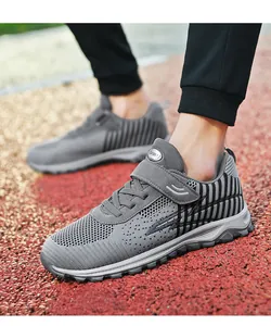 Detailed view of breathable grey fly-knit sneakers on a professional running track