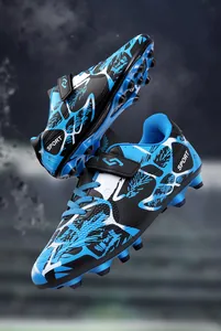 Détail de chaussures de foot enfant bleues et noires avec velcro et crampons robustes