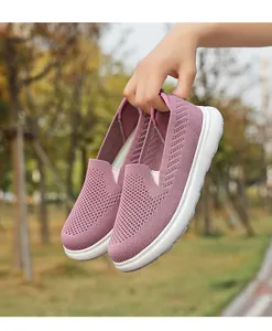 Detailed view of mauve breathable flying knitted mesh walking shoes held by hand