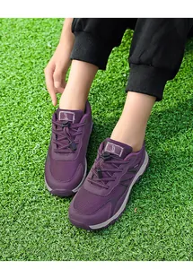 Close-up of purple breathable mesh walking shoes worn on green grass background