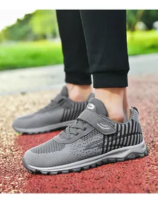 Grey fly-knit walking shoes with breathable mesh and Velcro strap on running track
