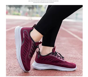 Macro view of wine-red breathable mesh walking sneakers on a red athletic track.