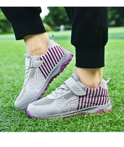 Close-up side view of grey and purple breathable mesh walking shoes on green grass