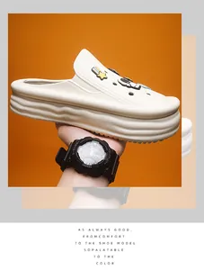 A hand holds a white chunky platform clog decorated with cartoon astronaut charms