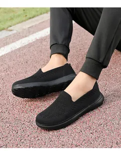 Close-up of black breathable flyknit mesh slip-on walking shoes on an outdoor track