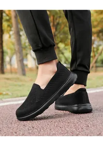 Detail view of breathable black flyknit mesh slip-on walking sneakers for men and women