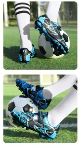 Détail de chaussures de foot pour enfants bleues et noires avec velcro et crampons.