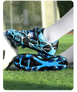 Gros plan de crampons de football bleus pour enfants avec détails de semelle sur herbe
