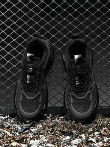 Zapatos de seguridad negros resistentes con hebilla giratoria y punta de acero.