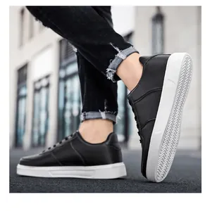 Close-up of black leather low-top sneakers with white flat soles in urban setting