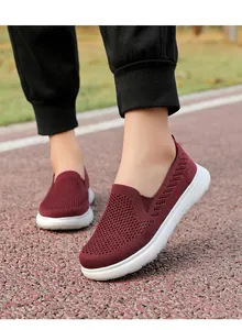 Detail shot of maroon breathable knitted slip-on walking shoes on outdoor track