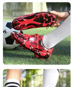 Vue détaillée de chaussures de foot enfant rouges avec scratchs et crampons de traction