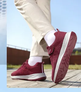 Scatto d'azione di sneakers rosse traspiranti in mesh su un ponte in legno all'aperto.